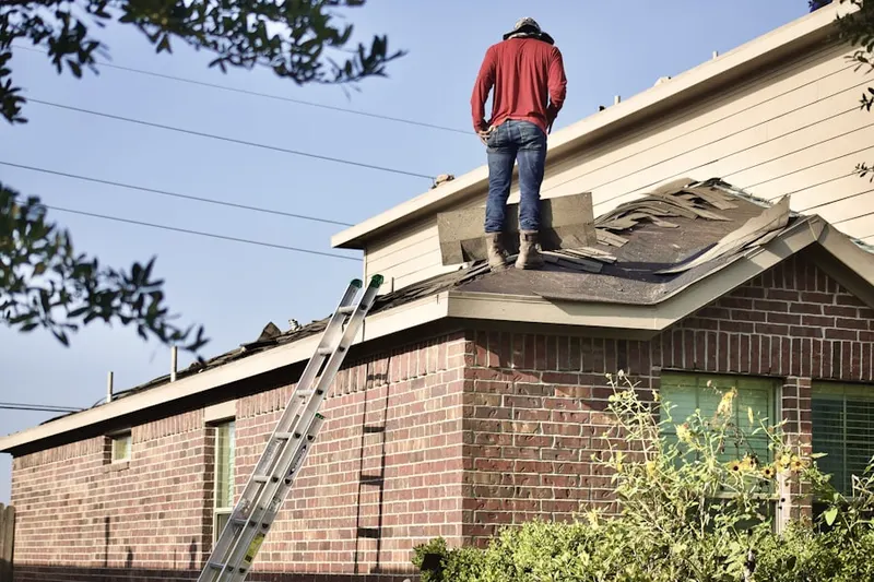 Professional roofer working on a residential roof in Broadmoor